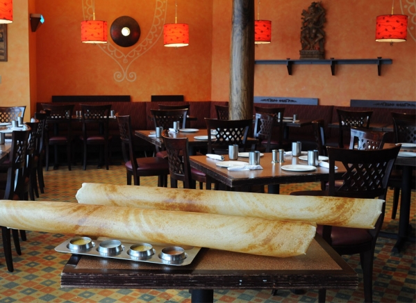 A large crispy South Indian Paper Dosa served fresh at a dining table inside Karaikudi Chettinad Restaurant