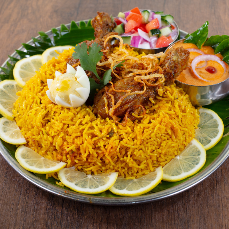Authentic aromatic Chettinad Chicken Biryani served with gravy and raita at Karaikudi Indian Restaurant in Scarborough