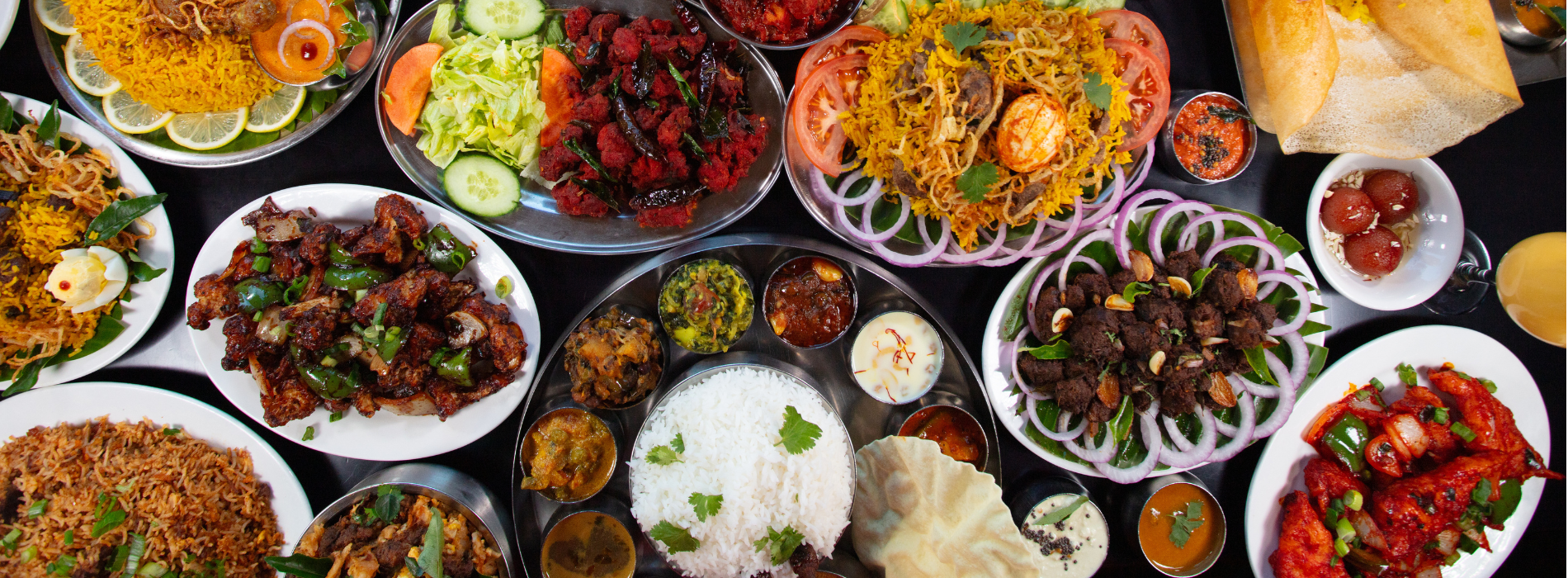 A large catering spread of authentic Indian food featuring traditional Chettinad dishes, curries, and appetizers at Karaikudi Restaurant Scarborough